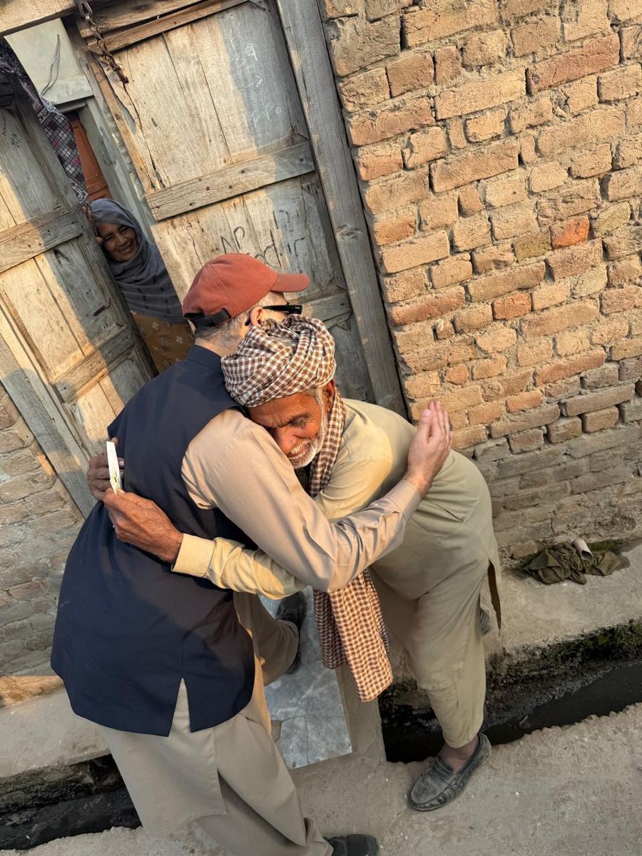 A volunteer embracing an elderly beneficiary